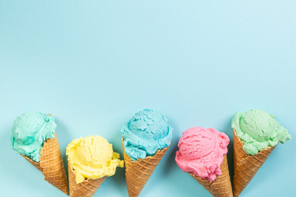 Pastel ice cream in waffle cones, bright background, copy space